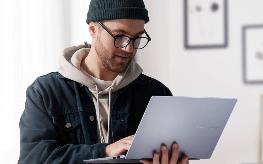 Homem concentrado segurando um notebook, ilustrando como formatar o notebook.