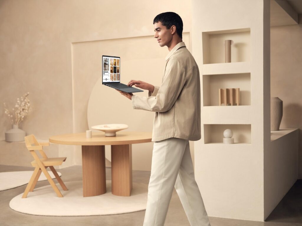 Homem usando o notebook leve Zenbook A14 em ambiente clean, destacando sua portabilidade.