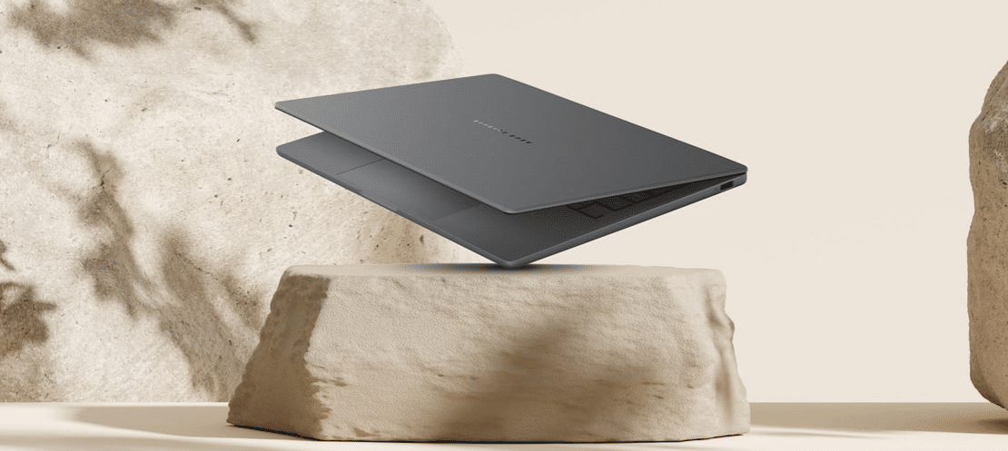 Imagem do notebook leve Zenbook A14 em tom cinza claro, aberto sobre uma pedra de cor bege, destacando seu design fino e portátil.